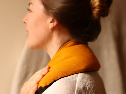 Woman with yellow and black heat pack on shoulders