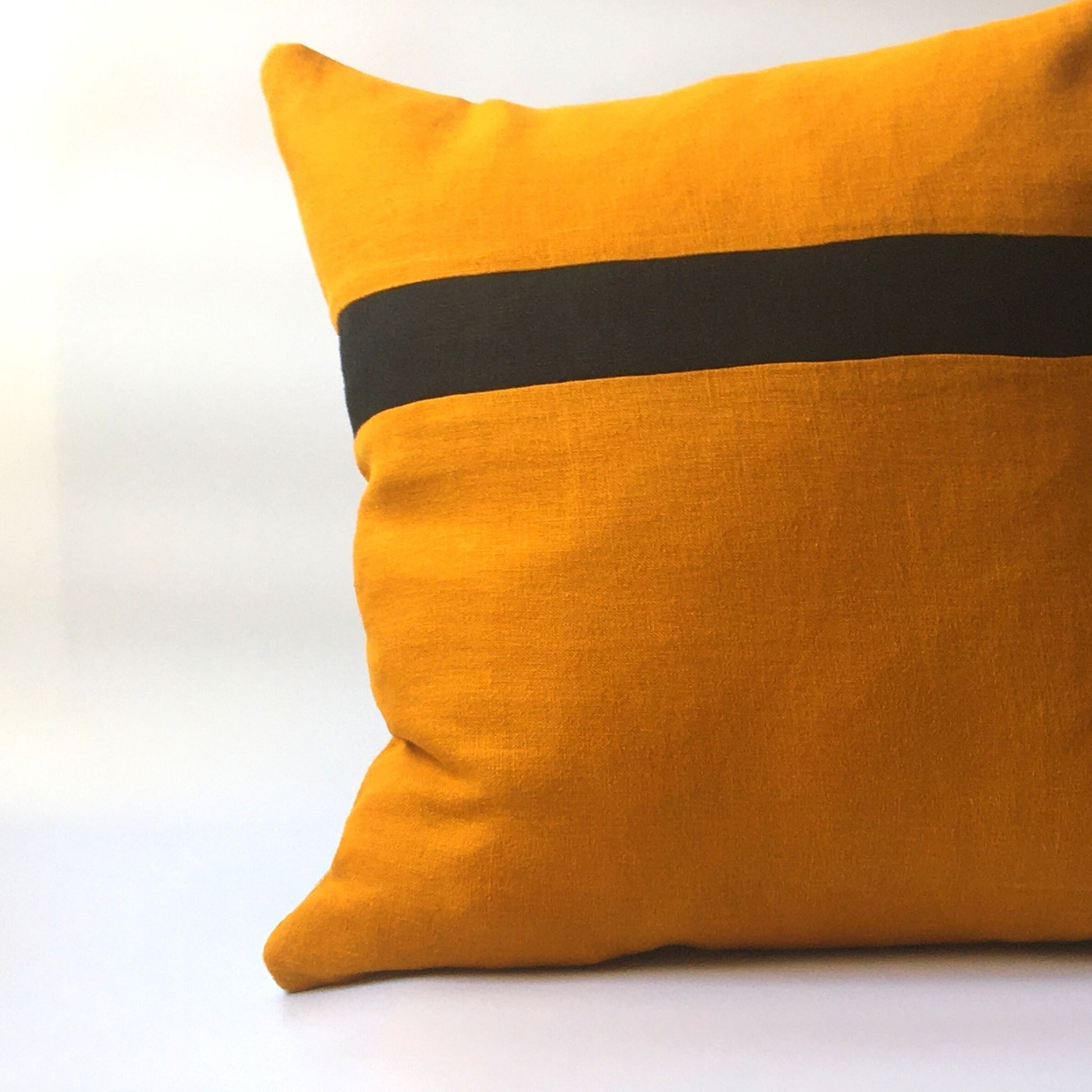 yellow cushion cover with black stripe running horizontally